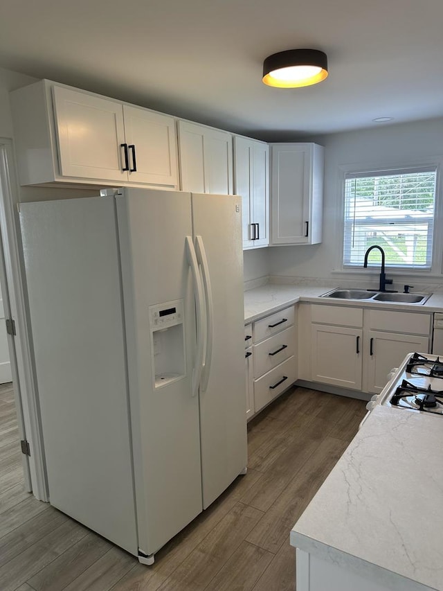 925 E Sangamon Ave, Rantoul, IL 61866 - kitchen featuring white refrigerator with ice dispenser, wood finished floors, white cabinetry, light stone counters, and range