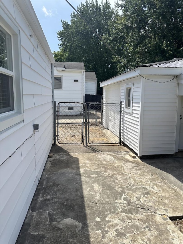 925 E Sangamon Ave, Rantoul, IL 61866 - view of patio with a gate, a detached garage, and an outbuilding
