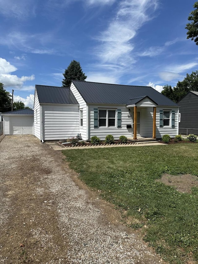 925 E Sangamon Ave, Rantoul, IL 61866 - view of front of house featuring a front lawn, a metal roof, dirt driveway, and an outdoor structure
