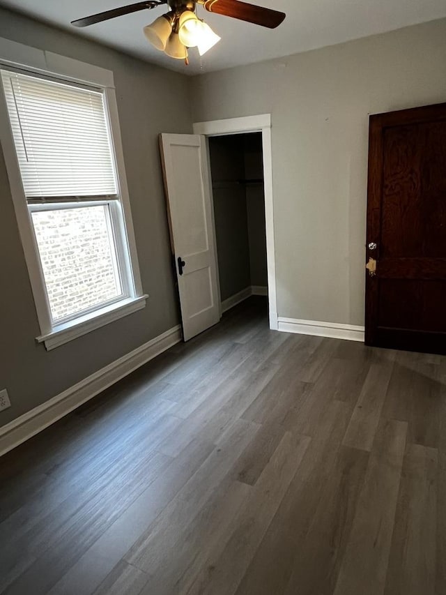 730 N Spaulding Ave, Chicago, IL 60624 - unfurnished bedroom featuring dark wood-style flooring, multiple windows, a closet, and ceiling fan