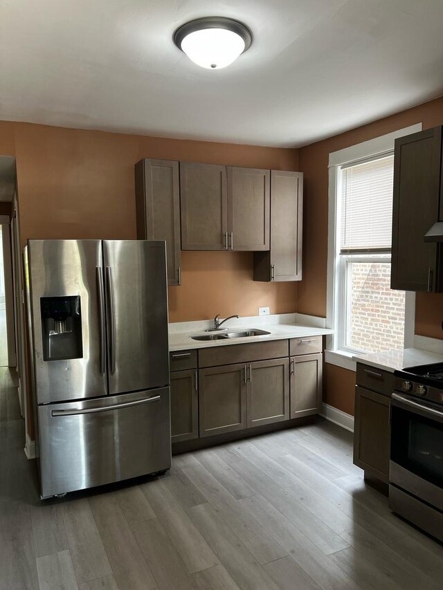 730 N Spaulding Ave, Chicago, IL 60624 - kitchen featuring stainless steel appliances, light wood finished floors, and light countertops
