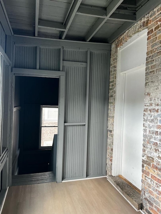730 N Spaulding Ave, Chicago, IL 60624 - spare room featuring wood finished floors, beam ceiling, and brick wall