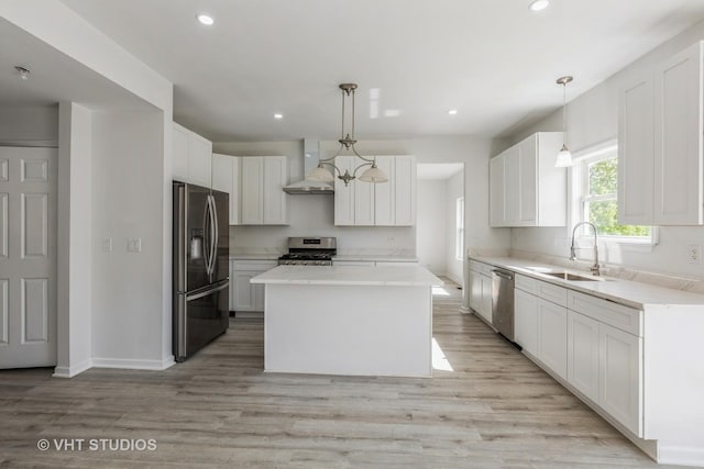 2895 Lahinch Ct, Aurora, IL 60503 - kitchen with stainless steel appliances, wall chimney range hood, light wood-style floors, white cabinets, and a kitchen island