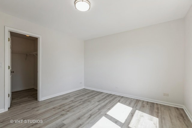 2895 Lahinch Ct, Aurora, IL 60503 - unfurnished bedroom featuring wood finished floors and a walk in closet