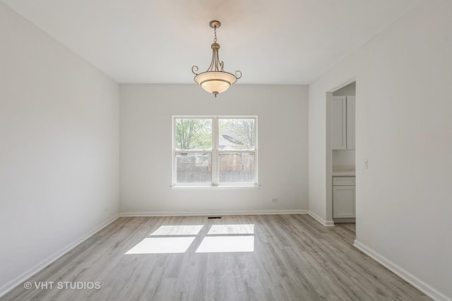 2895 Lahinch Ct, Aurora, IL 60503 - unfurnished dining area with light wood-style flooring and baseboards