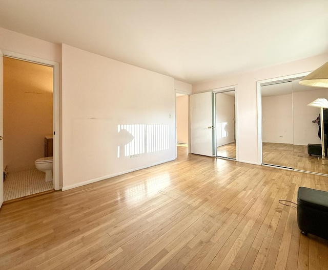 8928 Stevens Dr Unit 1A, Des Plaines, IL 60016 - unfurnished bedroom featuring two closets, light wood finished floors, and connected bathroom