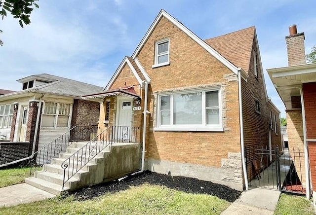 9302 S Eberhart Ave, Chicago, IL 60619 - view of front of house featuring brick siding, a shingled roof, and a gate