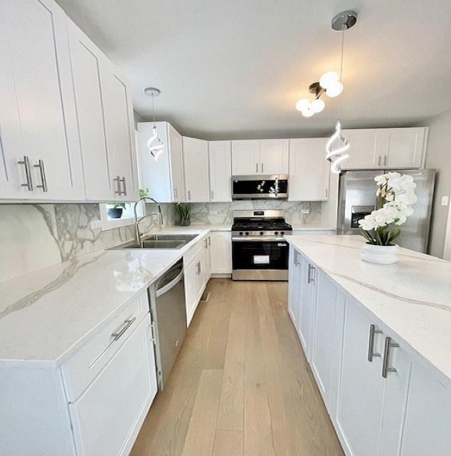 9302 S Eberhart Ave, Chicago, IL 60619 - kitchen with appliances with stainless steel finishes, light wood-style flooring, white cabinets, and light stone countertops