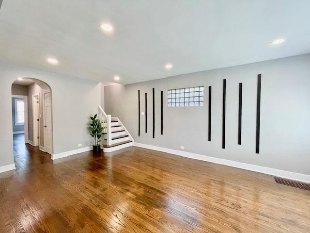 9302 S Eberhart Ave, Chicago, IL 60619 - empty room with arched walkways, wood finished floors, recessed lighting, and stairs