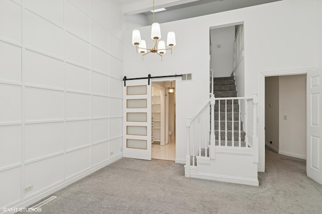 1315 Ardmore Dr, Round Lake Beach, IL 60073 - unfurnished room with stairway, carpet, a chandelier, a high ceiling, and a barn door