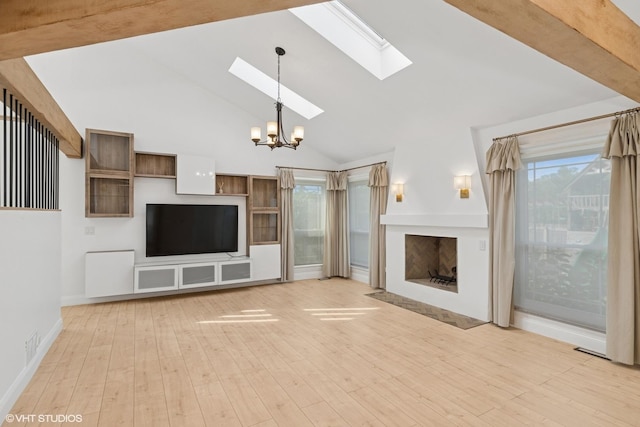 1315 Ardmore Dr, Round Lake Beach, IL 60073 - unfurnished living room featuring a skylight, high vaulted ceiling, a chandelier, wood finished floors, and a fireplace with flush hearth