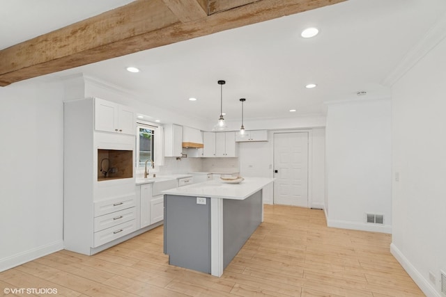 1315 Ardmore Dr, Round Lake Beach, IL 60073 - kitchen featuring white cabinets, tasteful backsplash, ornamental molding, a center island, and recessed lighting