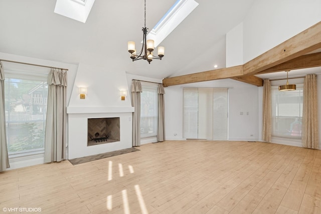 1315 Ardmore Dr, Round Lake Beach, IL 60073 - unfurnished living room with a skylight, a chandelier, vaulted ceiling, wood finished floors, and a fireplace with flush hearth
