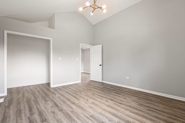 15355 7th Ave, Phoenix, IL 60426 - unfurnished bedroom with a chandelier, high vaulted ceiling, and wood finished floors