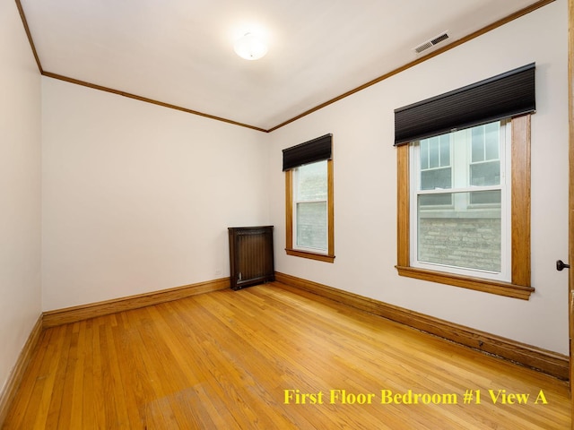 6527 N Onarga Ave, Chicago, IL 60631 - spare room featuring ornamental molding, plenty of natural light, light wood-style floors, and radiator