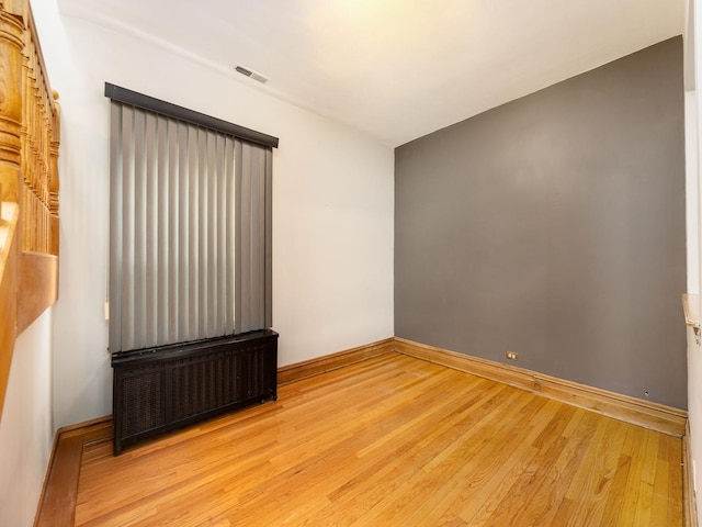 6527 N Onarga Ave, Chicago, IL 60631 - spare room featuring radiator and wood finished floors