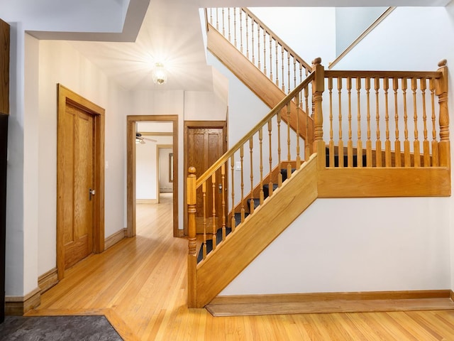6527 N Onarga Ave, Chicago, IL 60631 - staircase featuring wood finished floors, ceiling fan, and a baseboard radiator