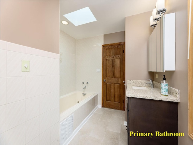 6527 N Onarga Ave, Chicago, IL 60631 - bathroom featuring a skylight, vanity, a tub to relax in, tile patterned flooring, and recessed lighting