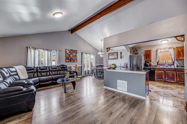 14801 S Harrison Ave, Posen, IL 60469 - living room featuring light wood finished floors, a chandelier, beam ceiling, and high vaulted ceiling