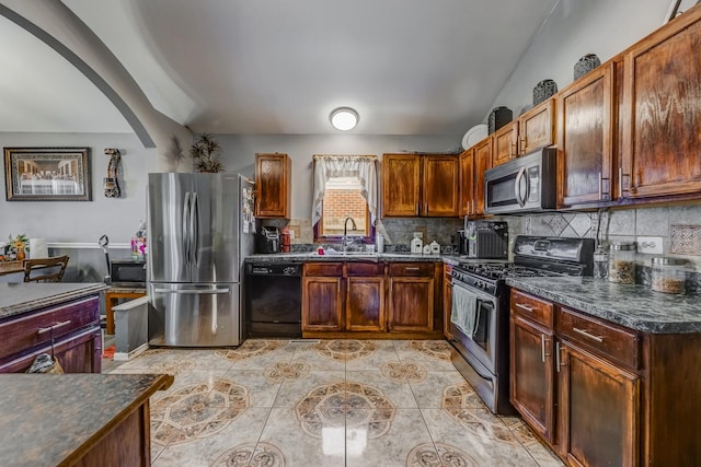 14801 S Harrison Ave, Posen, IL 60469 - kitchen with appliances with stainless steel finishes, dark countertops, decorative backsplash, light tile patterned floors, and arched walkways
