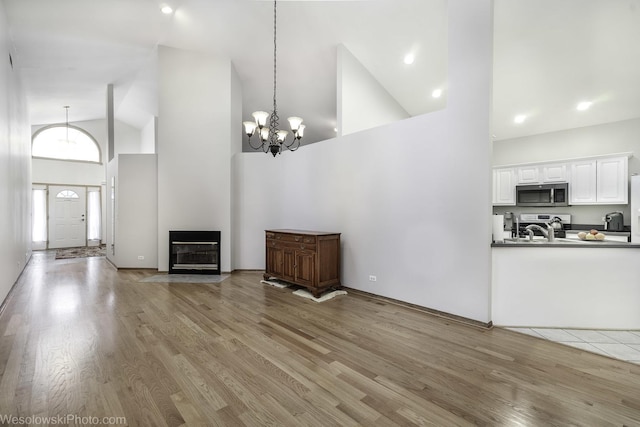 20739 N Weiland Rd, Prairie View, IL 60069 - unfurnished living room featuring high vaulted ceiling, light wood-style floors, and a chandelier