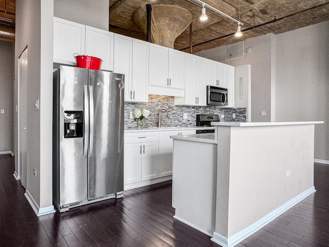 1550 S Blue Island Ave Unit 1125, Chicago, IL 60608 - kitchen featuring appliances with stainless steel finishes, track lighting, dark wood-type flooring, backsplash, and white cabinets