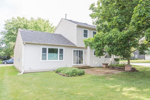 216 Dickens Trl, Elgin, IL 60120 - back of property featuring a lawn, a shingled roof, and a patio