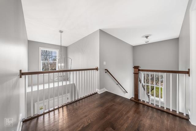 1122 W Wilson St, Palatine, IL 60067 - empty room with wood finished floors and a chandelier