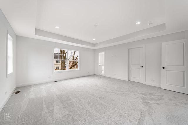 1122 W Wilson St, Palatine, IL 60067 - unfurnished bedroom featuring a tray ceiling, carpet floors, and recessed lighting