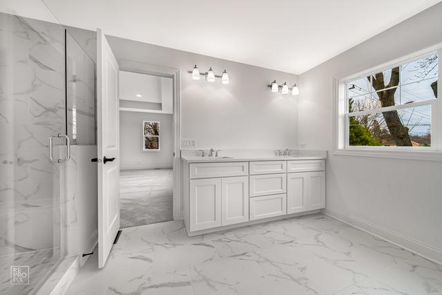 1122 W Wilson St, Palatine, IL 60067 - full bathroom featuring marble look tiles, a marble finish shower, and double vanity