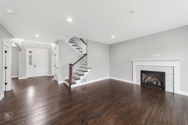 1122 W Wilson St, Palatine, IL 60067 - unfurnished living room with wood finished floors, stairway, arched walkways, recessed lighting, and a fireplace