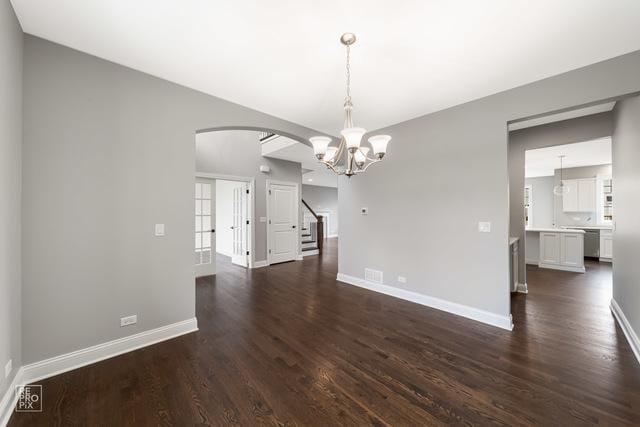 1122 W Wilson St, Palatine, IL 60067 - spare room featuring arched walkways, a chandelier, dark wood-style flooring, and stairway