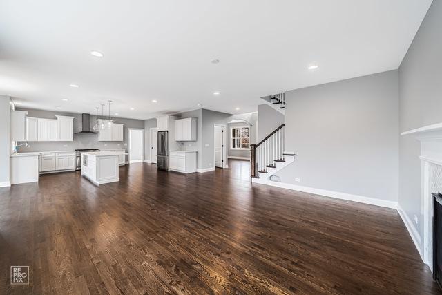 1122 W Wilson St, Palatine, IL 60067 - unfurnished living room featuring a fireplace, stairs, dark wood finished floors, arched walkways, and recessed lighting
