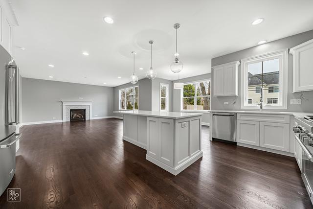 1122 W Wilson St, Palatine, IL 60067 - kitchen with stainless steel appliances, a kitchen island, white cabinetry, dark wood finished floors, and recessed lighting