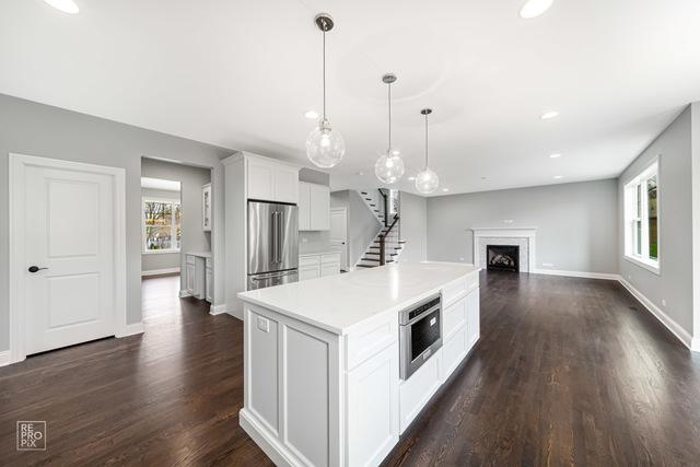 1122 W Wilson St, Palatine, IL 60067 - kitchen featuring stainless steel refrigerator, plenty of natural light, white cabinetry, dark wood finished floors, and recessed lighting