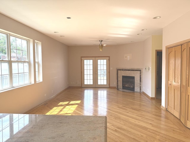 1136 Park Pl, Bellwood, IL 60104 - unfurnished living room with ceiling fan, light wood-type flooring, a tiled fireplace, french doors, and recessed lighting