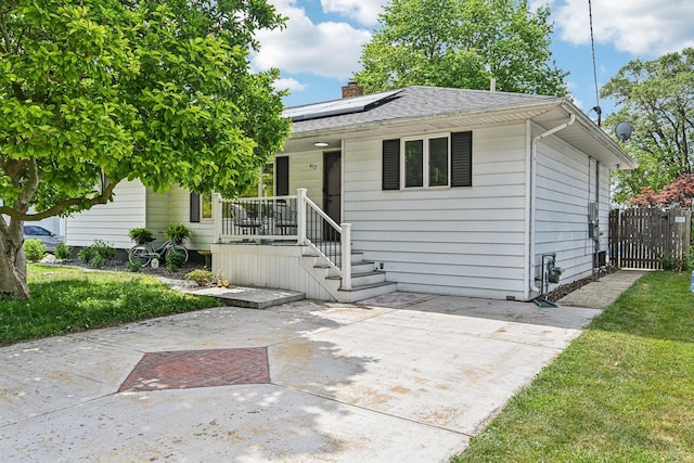 412 E S St, Peotone, IL 60468 - view of front of property with solar panels, a shingled roof, a chimney, and covered porch