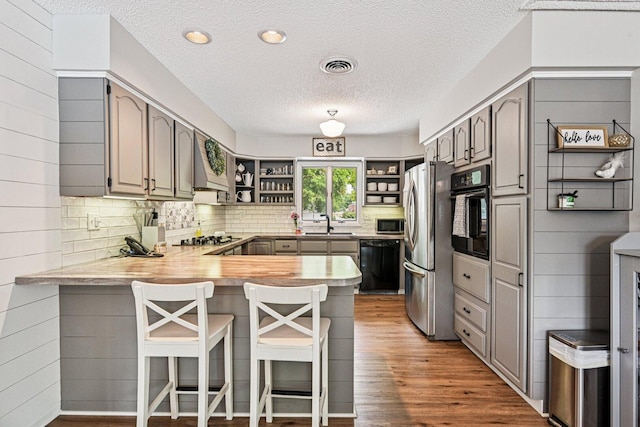 412 E S St, Peotone, IL 60468 - kitchen featuring black appliances, open shelves, a peninsula, gray cabinetry, and a textured ceiling
