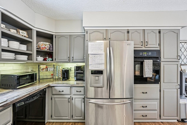 412 E S St, Peotone, IL 60468 - kitchen featuring black appliances, gray cabinets, a textured ceiling, backsplash, and light wood finished floors