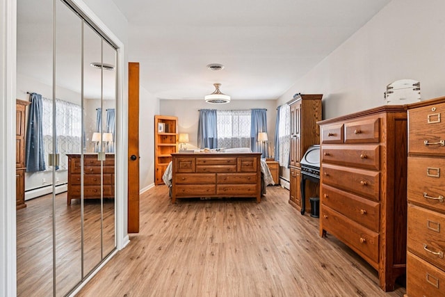 412 E S St, Peotone, IL 60468 - bedroom featuring a baseboard heating unit, light wood-style flooring, and multiple windows