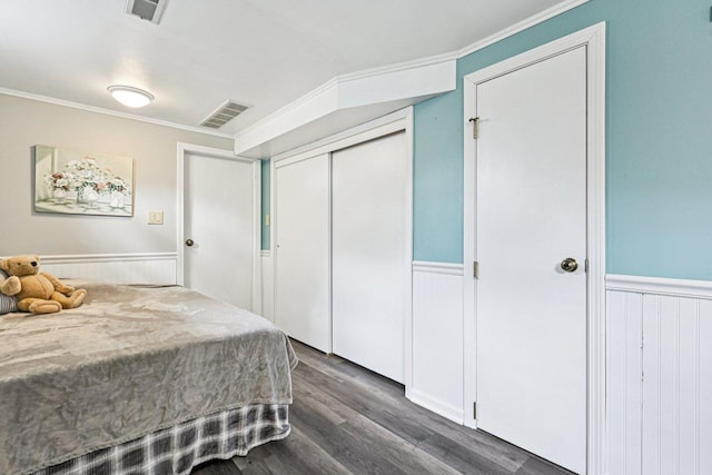 412 E S St, Peotone, IL 60468 - bedroom with wainscoting, dark wood-style flooring, a closet, and ornamental molding