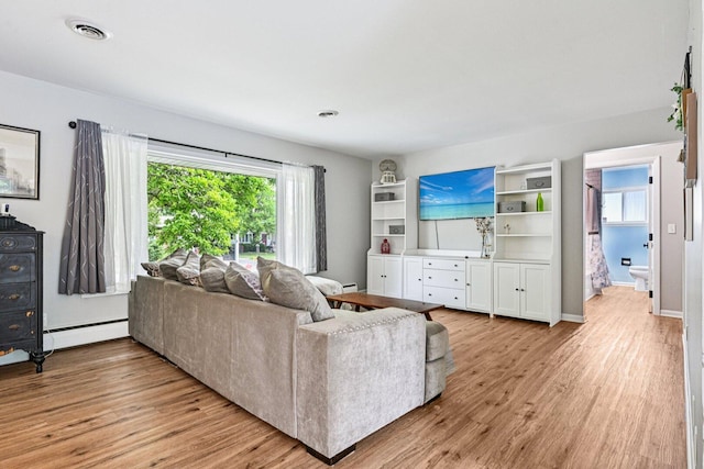 412 E S St, Peotone, IL 60468 - living area with baseboard heating, healthy amount of natural light, and light wood-style floors