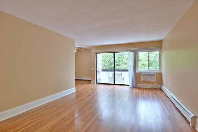 1813 Hemlock Pl Unit 306, Schaumburg, IL 60173 - spare room featuring baseboard heating, light wood finished floors, a wall mounted AC, and a baseboard radiator