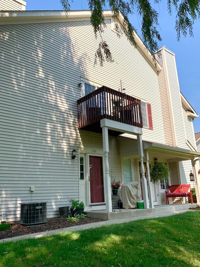 601 Fox Ridge Dr Unit 601, Fox Lake, IL 60020 - rear view of house with a balcony, a chimney, and a lawn