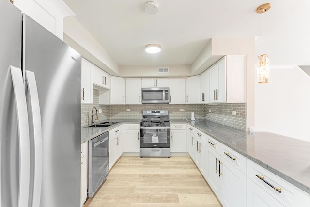 437 Winnebago St, Park Forest, IL 60466 - kitchen with appliances with stainless steel finishes, tasteful backsplash, white cabinets, and light wood finished floors