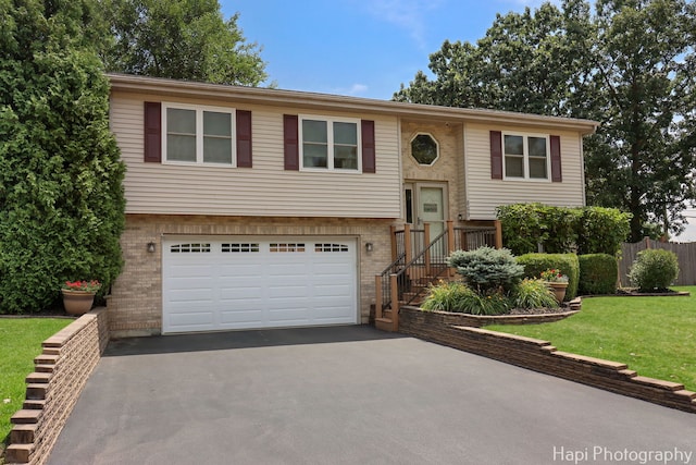 809 W Sheridan Rd, Mchenry, IL 60051 - split foyer home with asphalt driveway, a garage, brick siding, and a front lawn