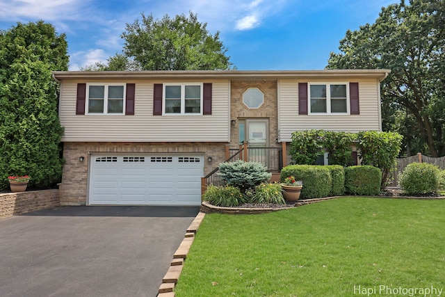 809 W Sheridan Rd, Mchenry, IL 60051 - split foyer home with asphalt driveway, a garage, and brick siding
