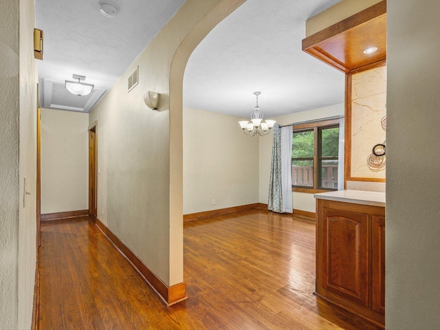 512 S Elida St, Winnebago, IL 61088 - corridor featuring dark wood-style floors, arched walkways, and a chandelier