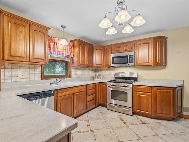 512 S Elida St, Winnebago, IL 61088 - kitchen with appliances with stainless steel finishes, a chandelier, backsplash, and brown cabinets