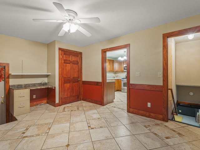 512 S Elida St, Winnebago, IL 61088 - empty room featuring ceiling fan, a desk, and wainscoting